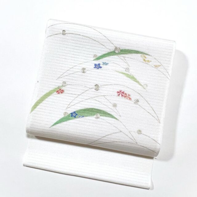 本日ご紹介致します商品は、絽ちりめん染名古屋帯「露芝」でございます。

上質な絽ちりめんを黄変防止加工を施し、生地白に露芝文様を表した夏単衣名古屋帯です。
上品な金彩で縁取り手描きで表した露芝の中には撫子や桔梗、女郎花、そして露を銀駒刺繍で表現しております。
工芸キモノ野口ならではの色使いで表現した極上の逸品、小紋やお召、紬の軽いカジュアルな付下げなどにあわせていただけます。

そして絽ちりめんですので、夏だけでなく単衣の時期もお使いいただけます。
今シーズンに限らず、夏単衣物の逸品物は年々少なくなっておりますので、お好みに合われましたら是非お早めにお申し付けくださいませ。
 
※価格は弊社ホームページのオンラインストアに記載しておりますのでご覧ください。
https://www.kyo-tsukamoto.co.jp/store/

 
【※帯の地色について】
撮影の加減で露芝の彩色が濃く映ったり、薄く映っている画像がございます。
そして画像では銀彩で縁取っている様にみえますが、実際は薄い金彩で縁取っております。
しかし刺繍は銀の駒刺繍ですのでご注意くださいね。
お使いのモニターによっても色の違いがどうしても出てしまいますが、何卒ご理解のほど宜しくお願い致します。
こちらの商品は「お手元確認」のシステムが可能ですので、もし宜しければご利用くださいませ。

#京呉服塚本
#塚本呉服店
#絽ちりめん夏名古屋帯#絽ちりめん#露芝#手描き#手刺繍#夏帯#夏単衣帯#工芸キモノ野口#京都#夏きもの#着物#キモノ#着物女子#着物好きな人とつながりたい#着物好きさんとつながりたい
